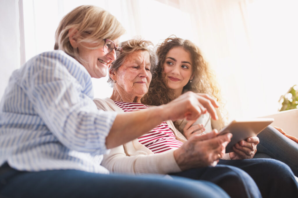 a,teenage,girl,,mother,and,grandmother,with,tablet,at,home.